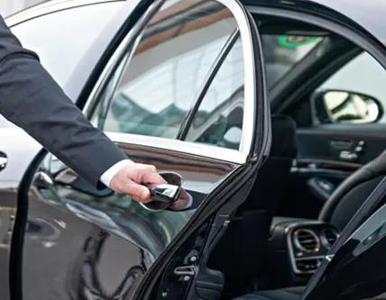 Een chauffeur opent het portier van de taxi
