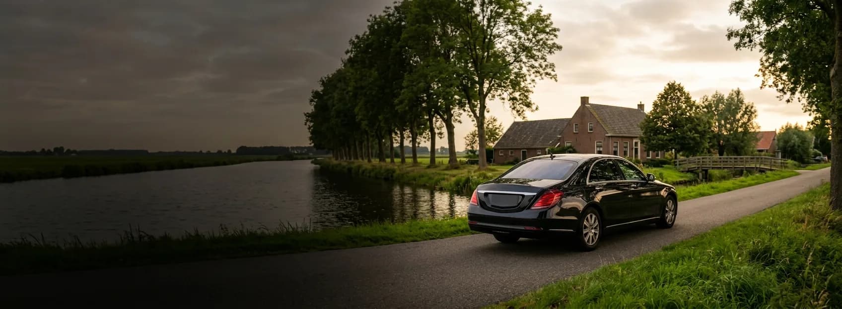 Een taxi op een landweg langs het water, bij zonsondergang