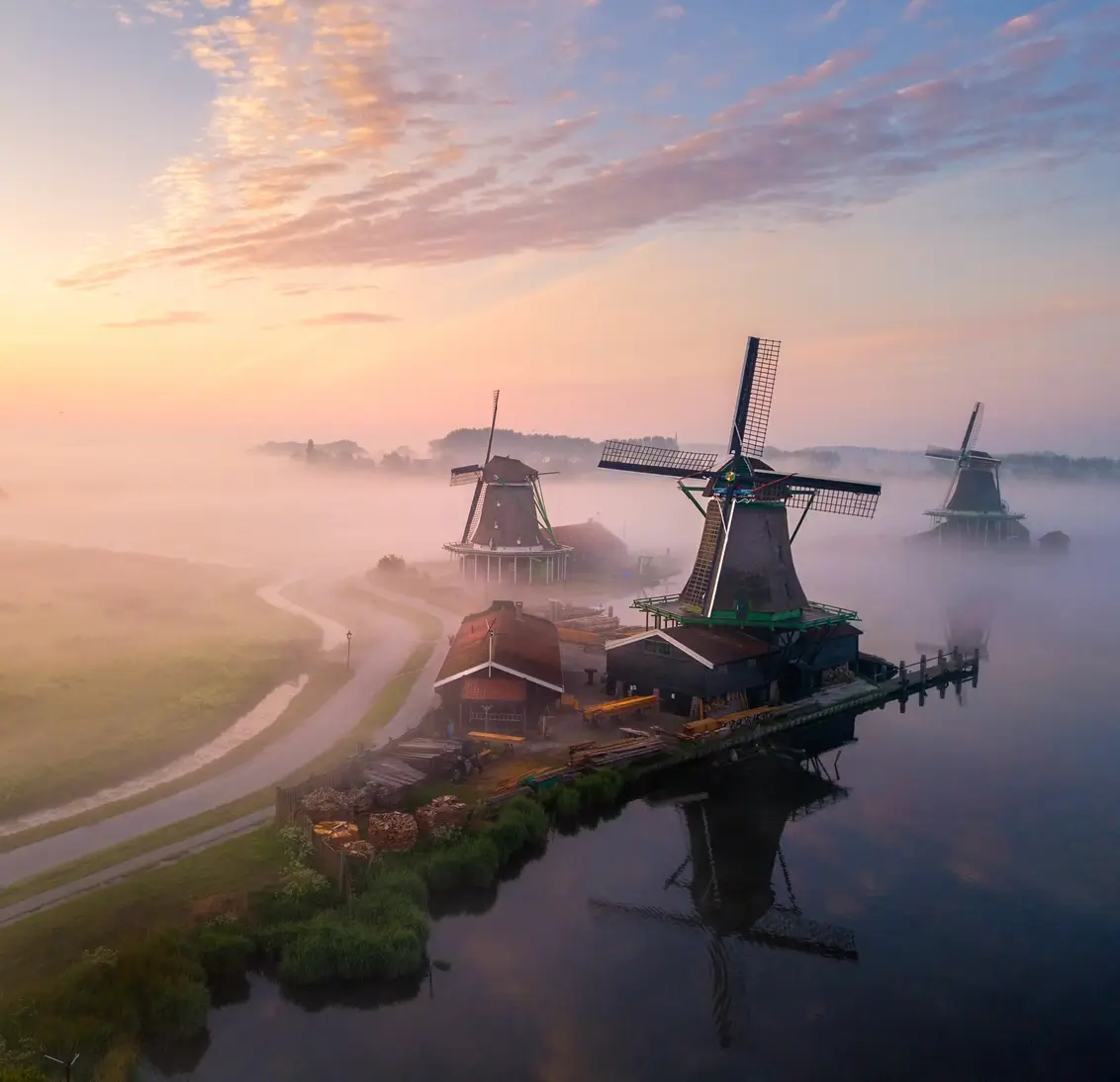 De molens van de Zaanse Schans in de mist, bij zonsopkomst
